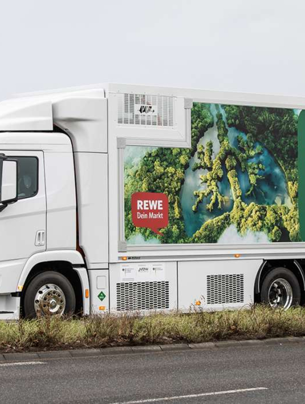 Ein Wasserstoff-Lkw vom Typ Hyundai XCIENT Fuel Cell. Auf der Seite steht „(K)ein Laster für die Umwelt. Ich fahre mit Wasserstoff! #UMDENKBAR“.