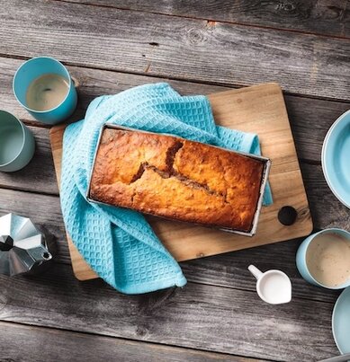 Ein veganes Bananenbrot auf einem gedeckten Kaffeetisch. 