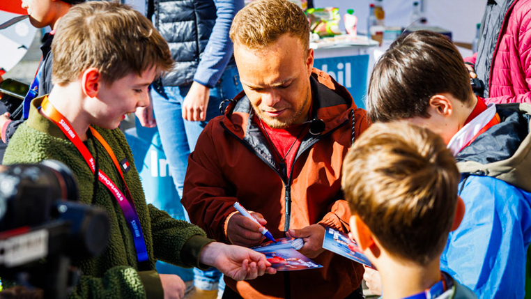 Paralympic-Kugelstoßer Niko Kappel gibt Kindern mit und ohne Behinderung Autogramme. 