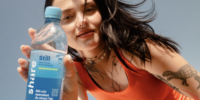 Eine Person hält eine Flasche share stilles Wasser.