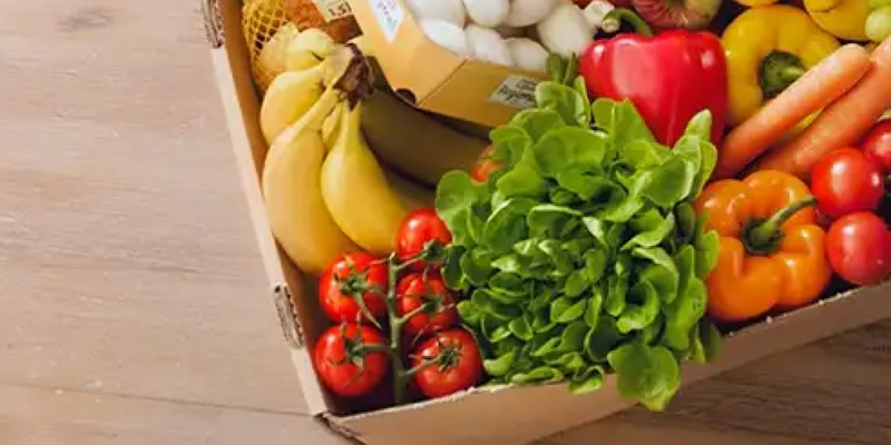 Karton mit frischem Gemüse und Obst gefüllt