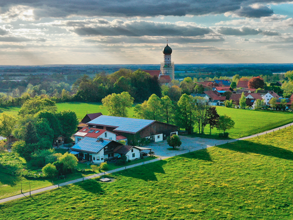 Der Jegglhof inmitten von Bäumen und Weiden. 